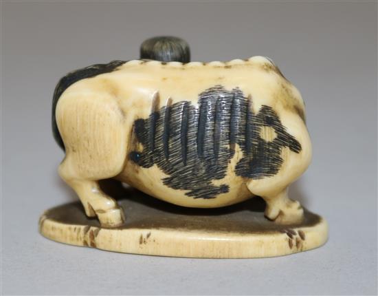 A Japanese ivory netsuke of a figure playing the flute standing by an ox, 19th century, 4.4cm